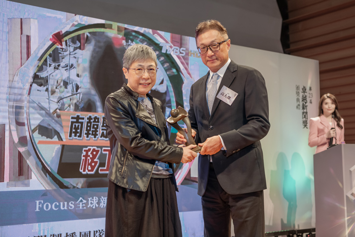 TVBS資深製作人林嘉娟（左）上台領獎，從高人傑手中接下獎座。