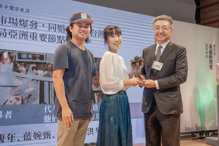 《報導者》團隊曹馥年（中）及林彥廷（左）從頒獎人、台灣期貨交易所副總經理陳錫琪（右）手中接下獎座。