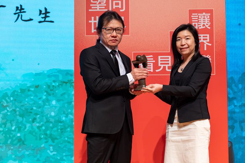 張乾琦（左）自頒獎人、富邦金控副總經理林茂生手中接下獎座。